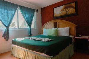 图斯特拉古铁雷斯马卡里奥斯酒店的一间卧室配有一张床,上面有两条毛巾
