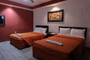 图斯特拉古铁雷斯马卡里奥斯酒店的酒店客房设有两张床,墙上挂有绘画作品