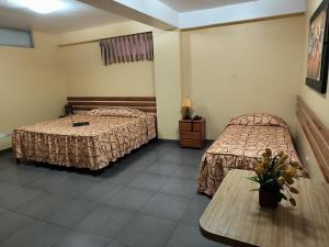利马Hotel Olaya的酒店客房设有两张床和一张桌子。
