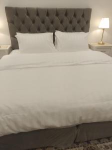 欧拉أستراحة مون لايت الريفي的一张白色的大床,配有灰色床头板和白色枕头