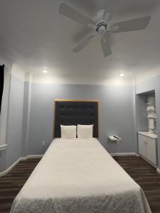 旧金山温莎堡酒店的一间卧室配有一张带吊扇的床