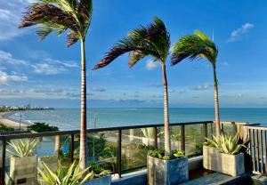 若昂佩索阿ARPOAR - Manaíra by PenareiaTurBr的阳台上种植了两棵棕榈树,俯瞰着大海