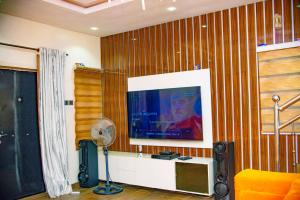 拉各斯Superb 2-Bedroom Duplex FAST WiFi+24Hrs Power的客厅配有平面电视和风扇。