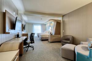 绍辛顿Courtyard by Marriott Southington的酒店客房带一张床铺、一张书桌和一间卧室