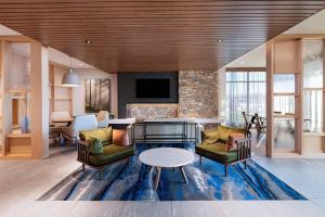 OskaloosaFairfield Inn & Suites by Marriott Oskaloosa的客厅配有桌椅