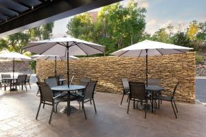 莱克伍德Fairfield Inn & Suites by Marriott Denver Southwest/Lakewood的一个带桌椅和遮阳伞的庭院。