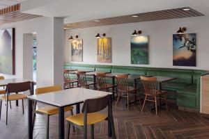 加洛韦Fairfield Inn & Suites Atlantic City Absecon的一间带桌椅和绿色长凳的餐厅