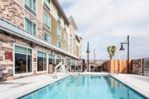 奥斯汀TownePlace Suites by Marriott Austin Parmer/Tech Ridge的大楼前的游泳池