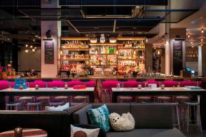 芝加哥Moxy Chicago Downtown的餐厅设有酒吧,配有粉红色的椅子和桌子