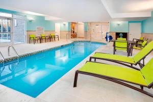 汉普顿SpringHill Suites by Marriott Hampton Portsmouth的大楼内一个带桌椅的游泳池