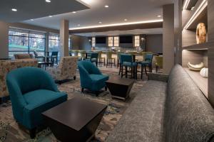 伦瑟姆SpringHill Suites By Marriott Wrentham Plainville的大堂设有蓝色的椅子和桌子