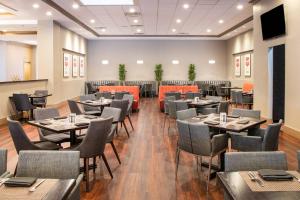 罗缪勒斯底特律大都会机场三角洲酒店的餐厅用餐室配有桌椅
