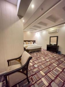 吉赞فندق مرسى جيزان的客房设有两张床、椅子和沙发。