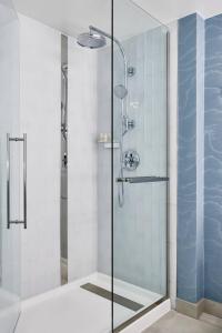 夏洛特夏洛特南方公园万丽酒店的浴室里设有玻璃门淋浴