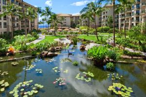 拉海纳The Westin Ka'anapali Ocean Resort Villas North的花园,花园内有花池和建筑