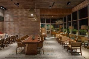 坦帕Aloft Tampa Midtown的餐厅设有木桌、椅子和窗户。
