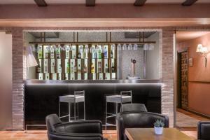 托莱多西尤达德托莱多AC万豪生活酒店的餐厅内的酒吧,配有椅子和葡萄酒瓶