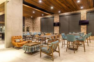 蒙特雷Four Points by Sheraton Monterrey Airport的一间带桌椅和电视的餐厅