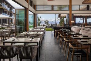 维雷亚AC Hotel by Marriott Maui Wailea的餐厅设有桌椅和窗户。