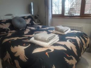德比ALVASTON, DERBY Entire 1 Bed House & South Facing Patio Garden的床上有一条毯子,上面有白鸟