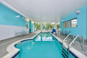 阿什本阿什本杜勒斯北SpringHill套房酒店的蓝色墙壁的建筑中的游泳池