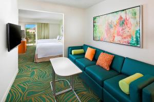 奥兰多万豪村奥兰多布埃纳维斯塔湖春季山丘套房万豪酒店的酒店客房配有蓝色的沙发和床。