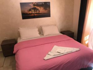 安曼Suzan Hotel Apartments的一间卧室配有一张粉红色的床,床上有长袍