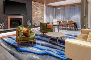 昆斯伯里Fairfield Inn & Suites by Marriott Queensbury Glens Falls/Lake George的大堂设有桌椅和壁炉。