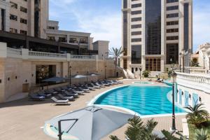 阿尔及尔Residence Inn by Marriott Algiers Bab Ezzouar的一个带椅子和遮阳伞的室外游泳池