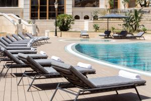 阿尔及尔Residence Inn by Marriott Algiers Bab Ezzouar的游泳池旁的一排躺椅