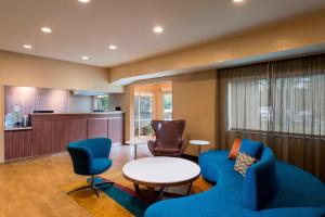 克利尔沃特Fairfield Inn and Suites St Petersburg Clearwater的一间设有蓝色椅子和桌子的等候室