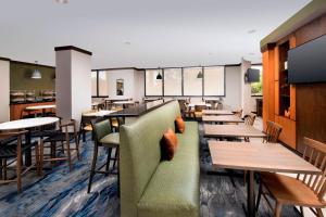 迈阿密万豪费尔菲尔德客栈及套房迈阿密机场南部酒店的餐厅设有桌椅和绿色沙发