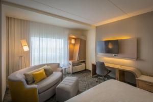 温尼伯温尼伯机场万怡酒店的配有一张床和一张书桌的酒店客房