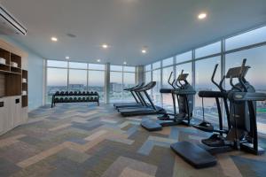 梅里达Residence Inn by Marriott Merida的一个带跑步机和椭圆机的健身房,位于带窗户的房间内