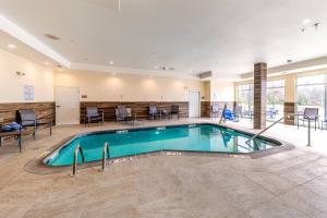 盖恩斯维尔Fairfield Inn & Suites by Marriott Gainesville I-35的酒店大堂的游泳池,配有桌椅