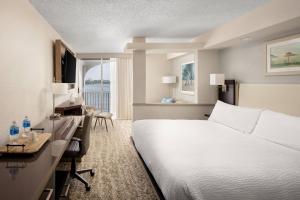 棕榈滩棕榈滩万豪费尔菲尔德客栈及套房酒店的酒店客房配有一张白色的床、一张书桌和一张书桌。
