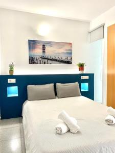 瓦伦西亚Acogedor Apartamento的卧室配有蓝色和白色的床,提供毛巾