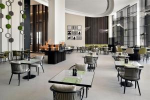 迪拜Courtyard by Marriott World Trade Centre, Dubai的一间带桌椅的用餐室和一间餐厅
