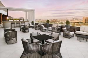 迪拜Courtyard by Marriott World Trade Centre, Dubai的一个带桌椅的庭院和一间酒吧