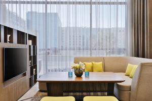迪拜Courtyard by Marriott Dubai, Al Barsha的带沙发、桌子和电视的客厅