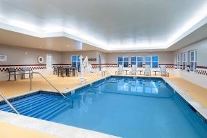北达特茅斯新贝德福德达特茅斯原住客栈的大型客房的大型游泳池,配有桌椅