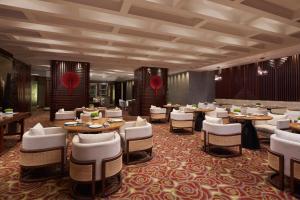 宁波宁波万豪酒店的用餐室配有桌子和白色椅子