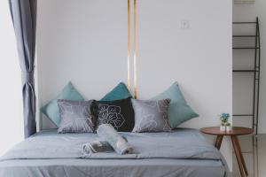 怡保Cozy Hillside SuiteThe Cove Ipoh 9-11 Pax的床上有蓝色和灰色的枕头