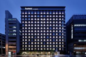 大阪Fairfield by Marriott Osaka Namba的上面有酒店标志的高楼