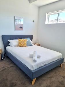 阿斯彭达尔Aspendale Beach Escape -Walk To Mordialloc的一间卧室配有一张大床和两条毛巾