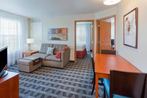 圣路易斯帕克西明尼阿波利斯/圣路易斯公园万豪广场套房酒店的客厅配有沙发和1张床