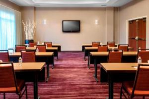 伊丽莎白Courtyard by Marriott Newark Elizabeth的客房设有桌椅和平面电视。