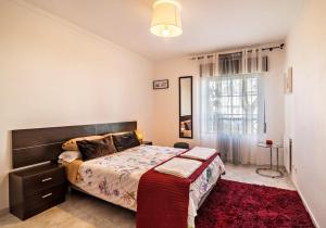 塔维拉Casa da Praia, Santa Luzia的一间卧室配有一张大床和红色地毯。