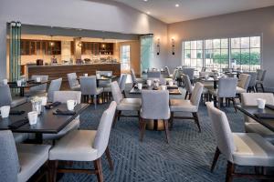 诺福克Delta Hotels by Marriott Norfolk Airport的一间带桌椅的餐厅和一间酒吧
