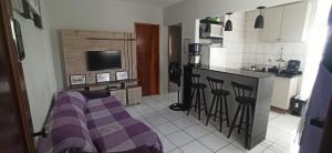布拉干萨-保利斯塔Apto com estacionamento, piscina e churrasqueira的客厅设有带紫色沙发的厨房